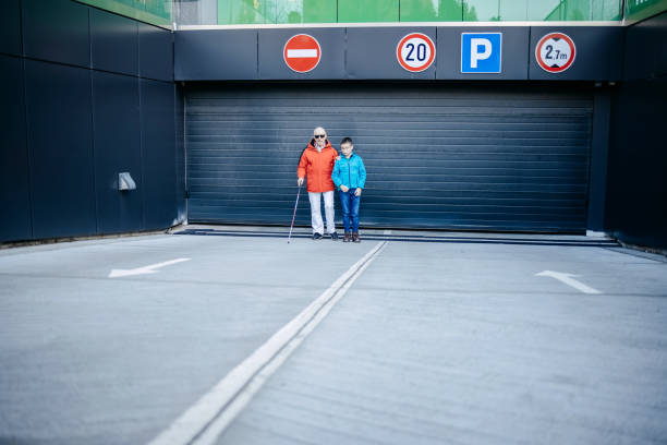istock Child supporting blind old person with climbing stairs and walk 1483084750
