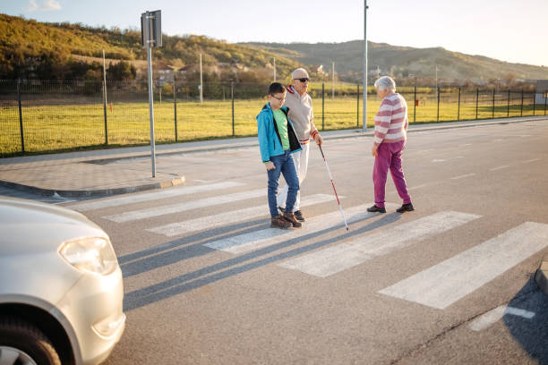 istock Kid support old person with disability to cross street 1483084805