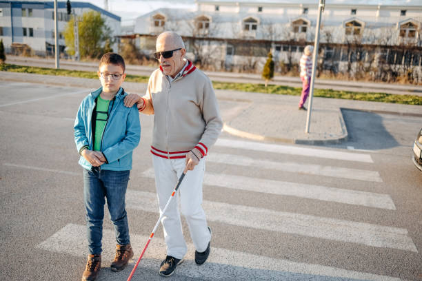 istock Kid support old person with disability to cross street 1483084812