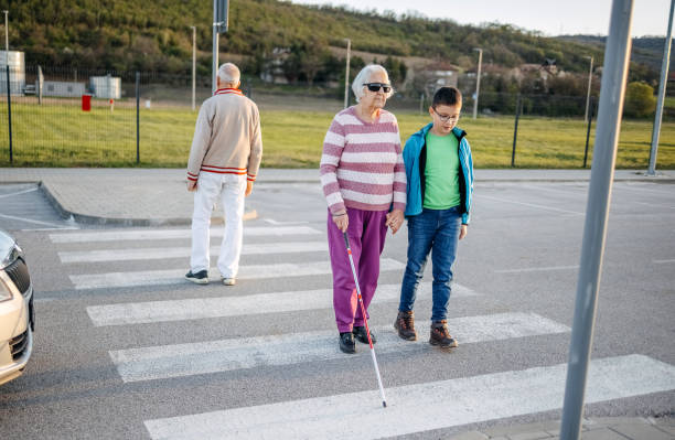istock Kid support old person with disability to cross street 1483084820