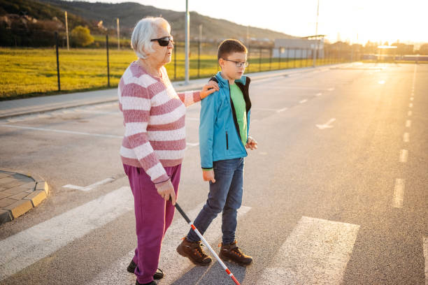 istock Kid support old person with disability to cross street 1483084824