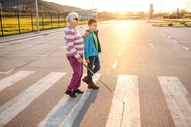 Kid support old person with disability to cross street