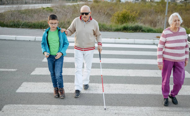 istock Kid support old person with disability to cross street 1483084830
