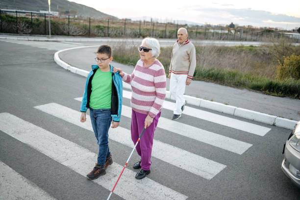 istock Kid support old person with disability to cross street 1483084836