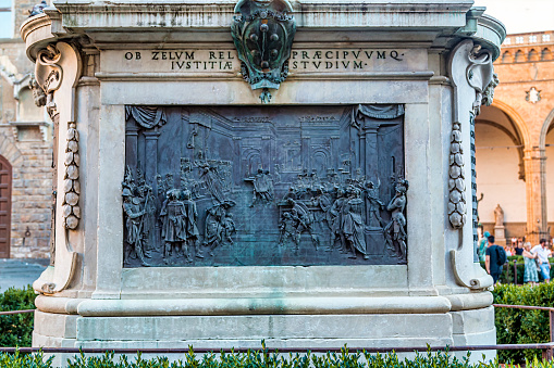 Florence, Italy - August 13, 2016 -Mural at the base of Equestrian Monument of Cosimo I. The inscription highlights Cosimo I's role as the first Grand Duke of Tuscany and as a key figure in the unification and development of the region. The date 1872 refers to the year when the statue was installed in its current location in the Piazza della Signoria.