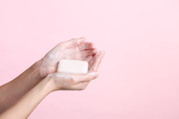 istock Female hands holding foaming soap on a pink background. Hygiene, clean hands 1483085969