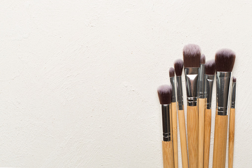 Make up brushes on concrete background, top view