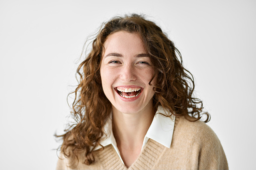 Young smiling charming positive woman, happy joyful cheerful cute curly girl student laughing having fun, looking at camera, standing isolated at white background, close up headshot portrait.