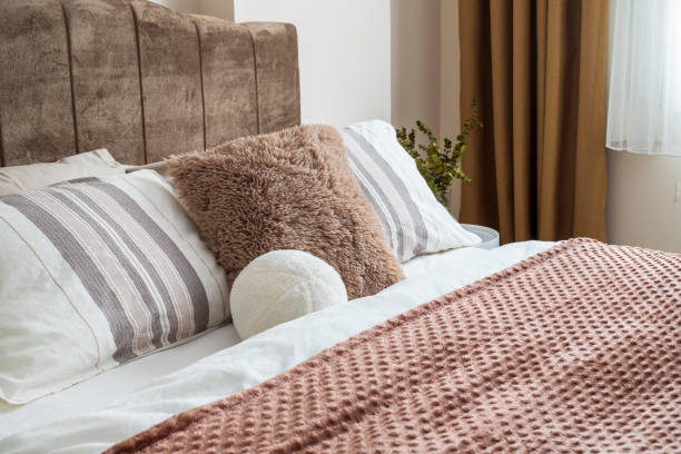 istock Stylish bedroom interior design with creamy white pillows on the bed. 1483091137