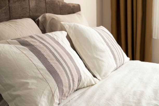 istock Stylish bedroom interior design with creamy white pillows on the bed. 1483091152