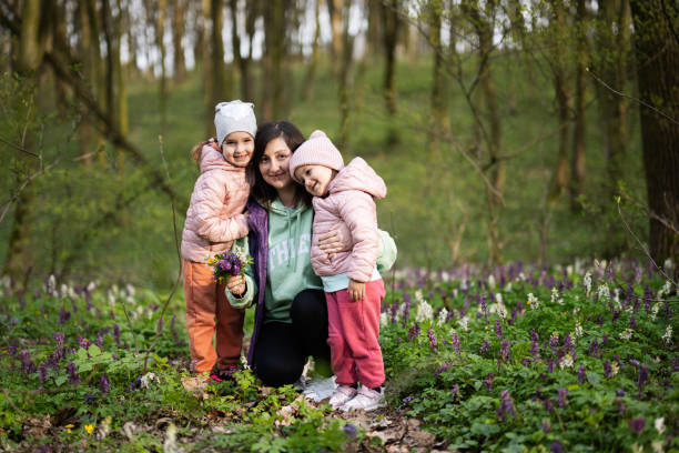Child holding a small bouquet of purple wildflowers