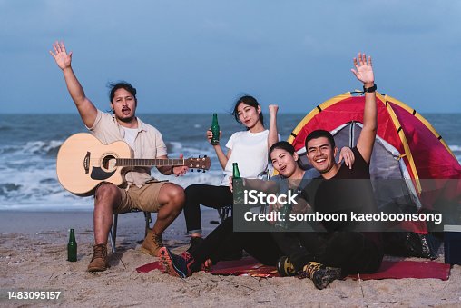 istock Backpacking group, Asian men and women, partying, chatting and drinking fun, camping on the beach, seaside, outdoor adventure and relaxation. Concept - looking at the camera. 1483095157