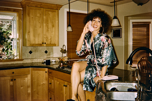 A woman at home with a 1970’s/1980’s vintage feel. Shot on 35mm film with an old camera, for authentic retro look.