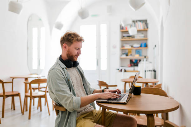 istock Ginger businessman using laptop and having video call at coffee shop 1483095754