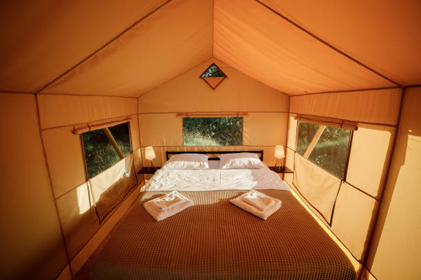 istock Interior of Cozy open glamping tent with light inside during sunset. Luxury camping tent for outdoor summer holiday and vacation. Lifestyle concept 1483096962