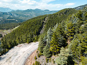 Aerial mountain range view, valley, dirt roads, snowy mountains, road landscape