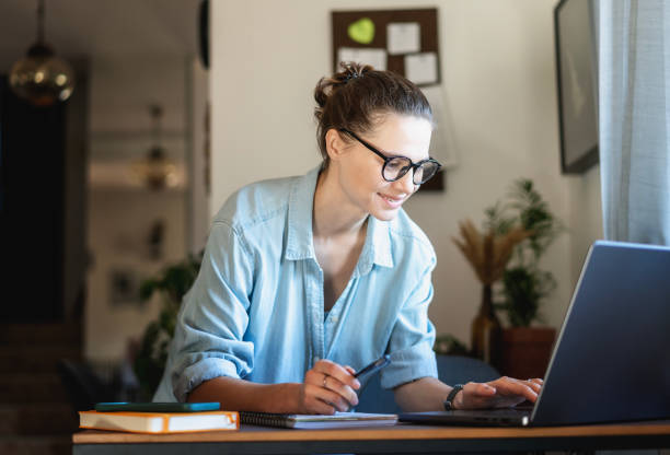 istock Young business woman freelancer making notes in diary at table with laptop while working on projects at home 1483097726