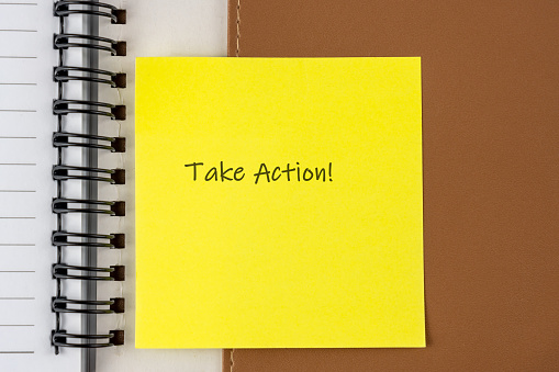 Yellow adhesive paper note with text Take Action