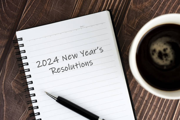istock Cup of coffee and notepad with text - 2024 New Year's Resolutions 1483099237