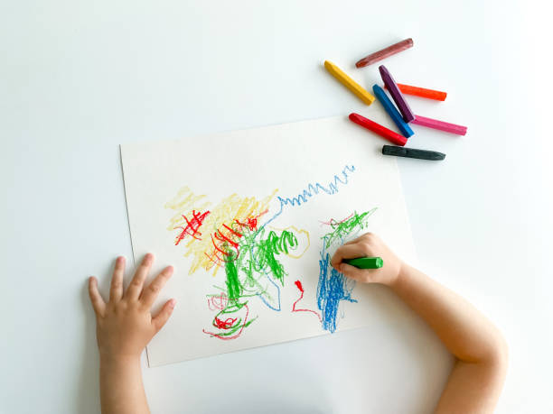 istock small child draws with pastel crayons on white table. fathers day 1483099539