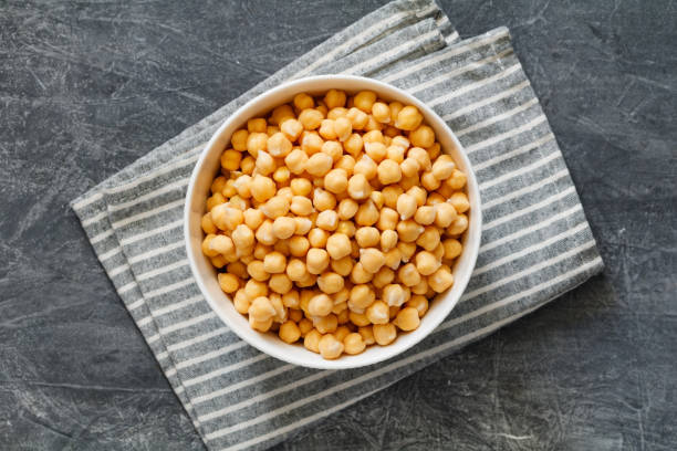 istock Cooked or canned chickpeas in a white bowl on a table, top view. 1483102690