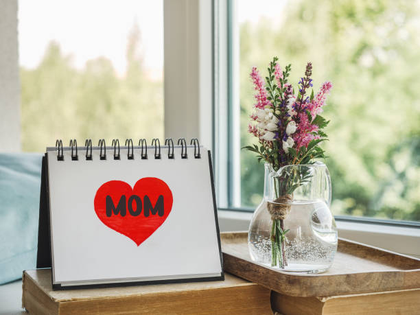 istock Notepad with the word MOM. Closeup, indoors 1483102696