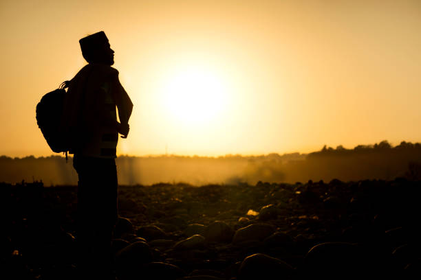 Silhouette image of an Indian young man enjoying the beautiful view of sunset in the mountains.