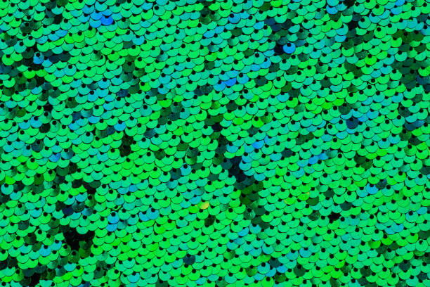 istock Green round shaped sequins attached to the fabric. Background texture 1483105229