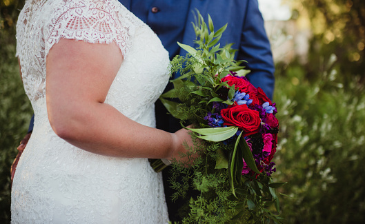 Plus size bride with wedding dress and flowers