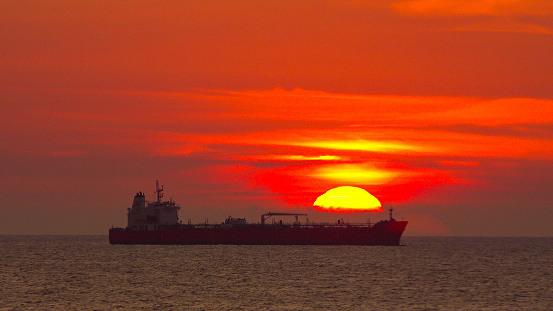 The sun sets over a cargo ship off the coat of Colombia