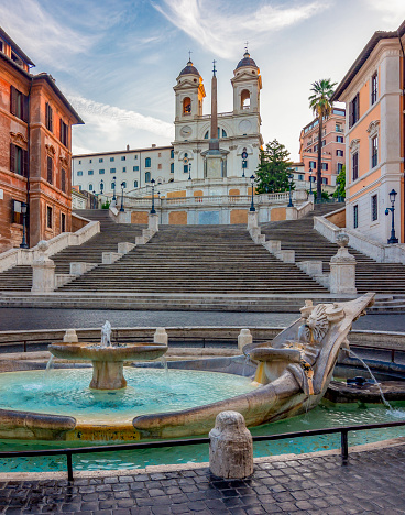 Fuente de la Barca y Plaza de España con la iglesia de la Trinidad dei Monti en Roma, Italia photo