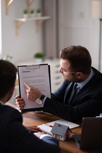 Estate agent shaking hands with his customer after contract signature