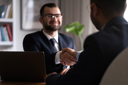 Estate agent shaking hands with his customer after contract signature