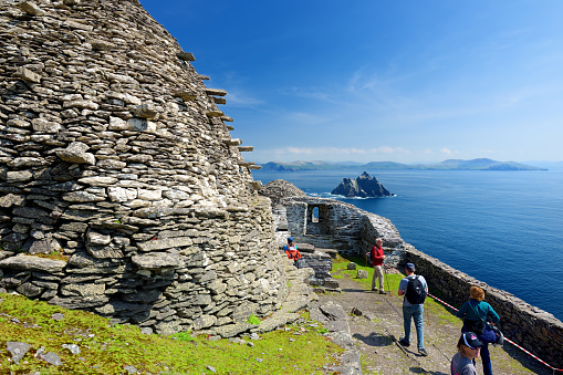 Skellig Michael, Ireland - May 22, 2018: Tourists exploring Skellig Michael, home to ruined remains of a Christian monastery, inhabited by variety of seabirds, UNESCO World Heritage Site, Ireland.
