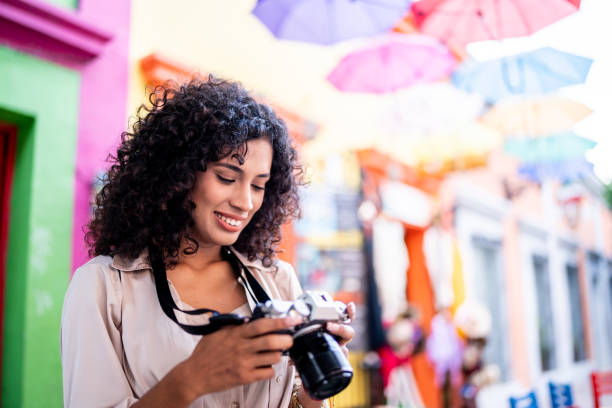 Young tourist woman looking at pictures on a camera outdoors