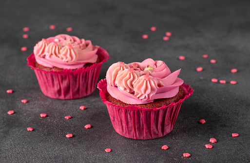 Cupcakes Red velvet decorated with pink cream on dark background