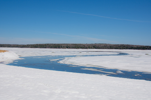 Melting ice in the spring on a lake in the Canadian forest in Quebec