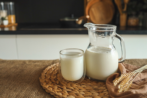Fresh natural milk in a glass and jug at home.