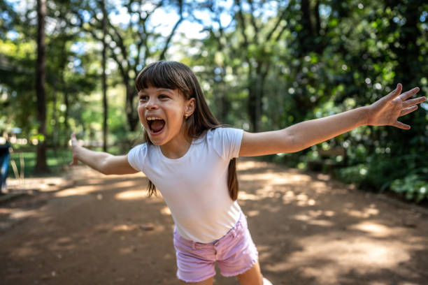 istock Girl with arms open at the park 1483138281