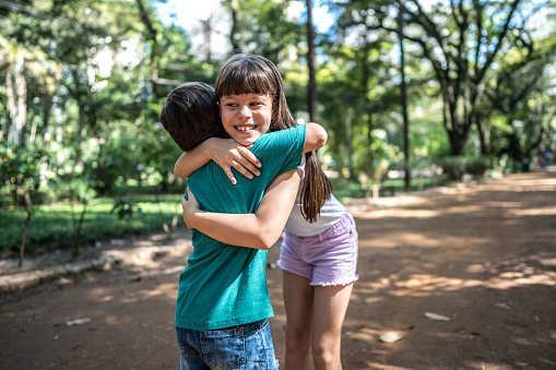 Siblings embracing outdoors