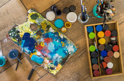 High angle view of brushes, pallete, oils, acrylics and other elements of a painter artist. Art workshop. Background.