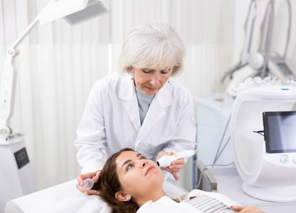 istock Young woman having face laser therapy procedure by specialist 1483139510