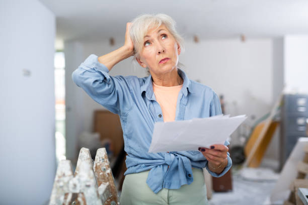 Stressed woman with papers in renovating house