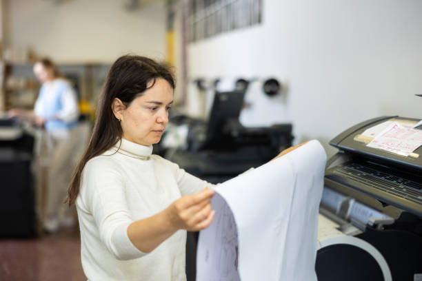 istock Woman checking large format paper after printing 1483141360