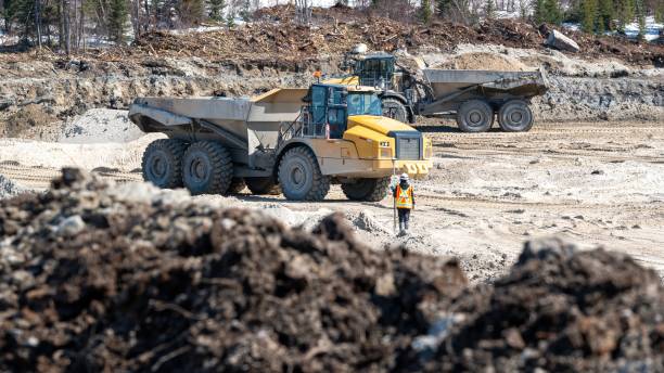 istock Dumpers driving on a construction site and a surveyor 1483145616
