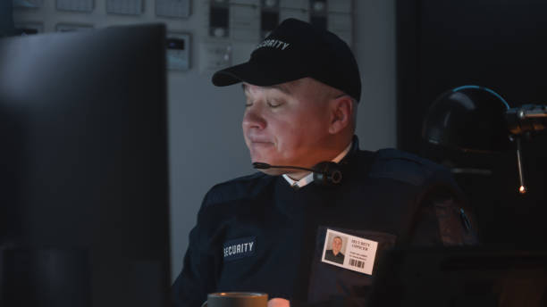 istock Tired security officer drinks cup of coffee 1483146429