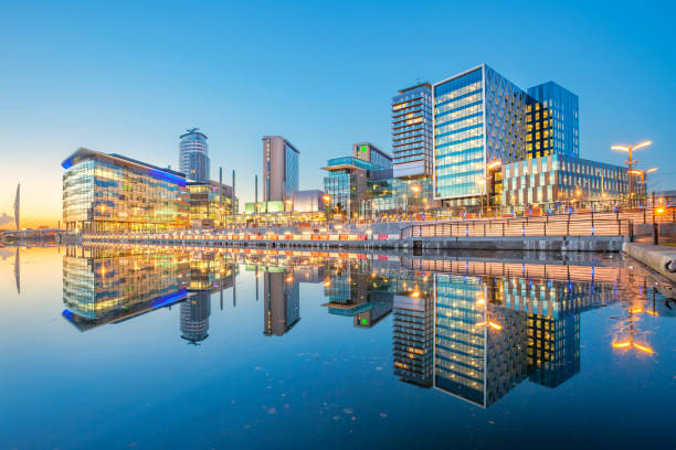 Manchester England Salford Quays Skyline Reflection Office buildings and apartments in the Salford Quays area of Manchester, England, United Kingdom at twilight blue hour. manchester england stock pictures, royalty-free photos & images