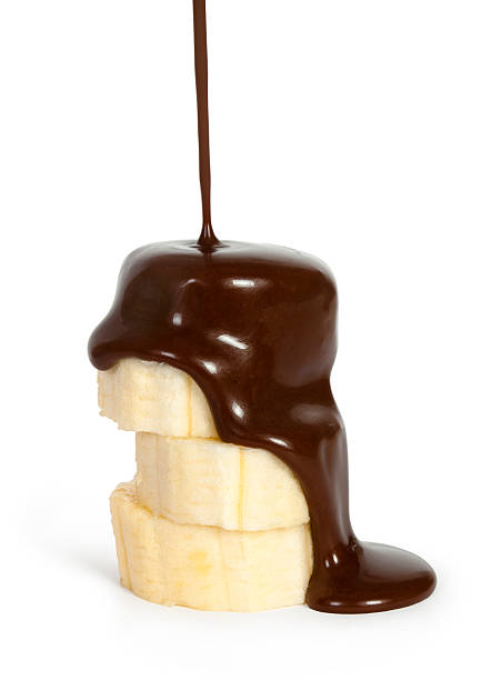 sliced ripe banana with poured chocolate isolated on white