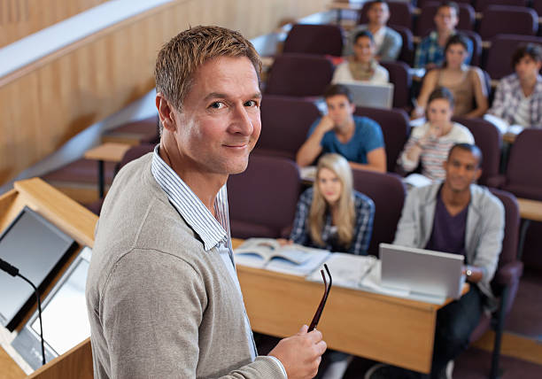 portrait de souriant professeur au podium avec étudiants de l'université - women professor mature adult human face photos et images de collection