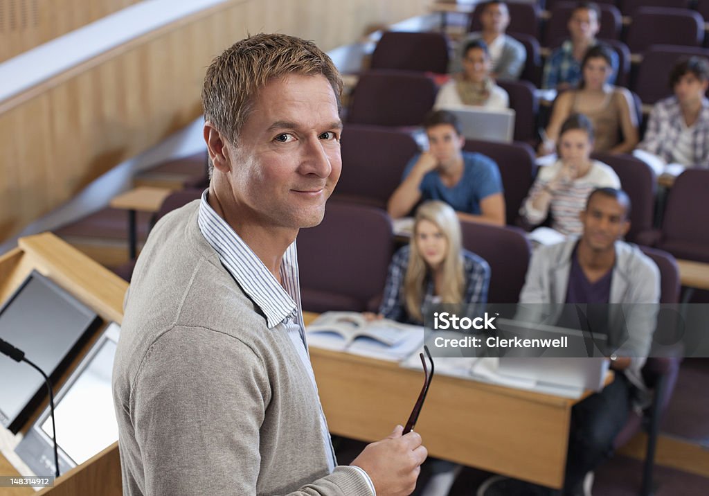 Portret uśmiechnięta Profesor na podium z studentów - Zbiór zdjęć royalty-free (Wykładowca szkoły wyższej)